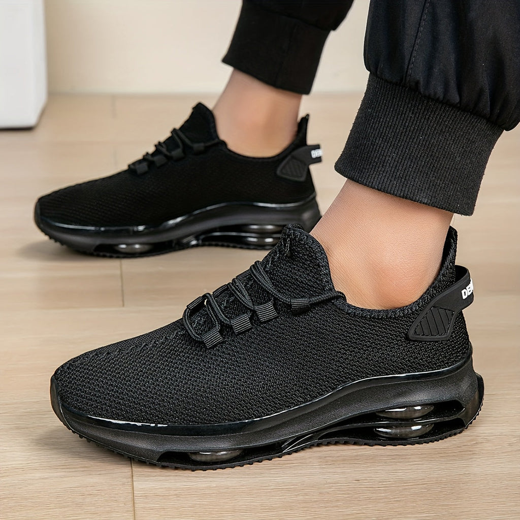 Black knit trainers worn on feet, side view standing