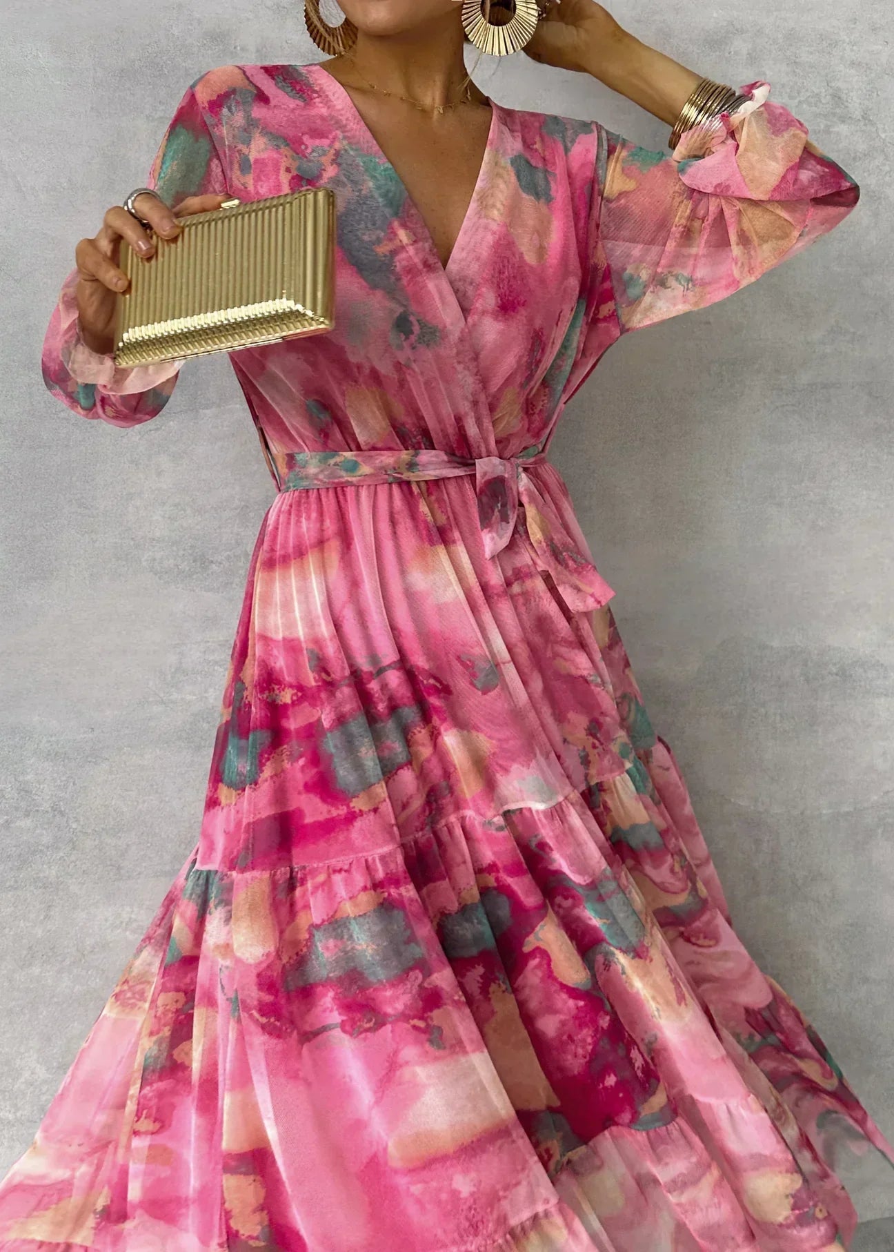 Women's flowing floral pleated maxi dress with defined waist belt, side view