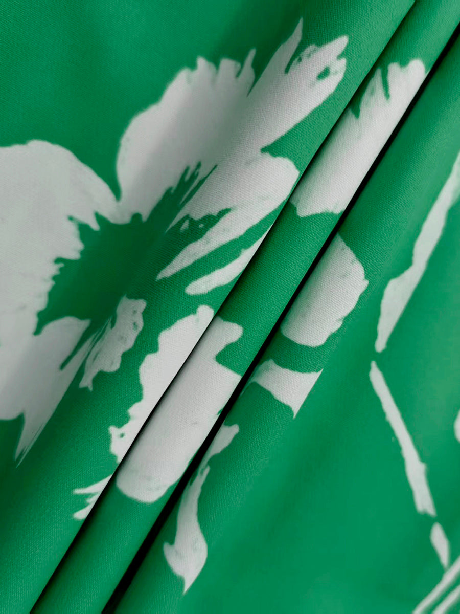 Close-up of green and white floral print fabric with folds