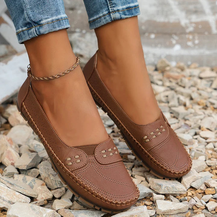 Women's flat slip-on loafers in brown, styled on foot