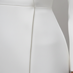 Women's structured white dress detail showing high collar and fitted waist