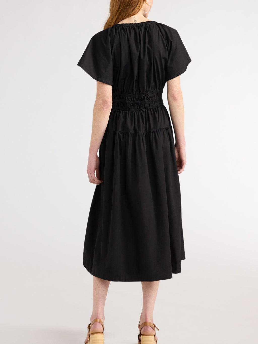 Women's denim tiered dress with side pockets, back view