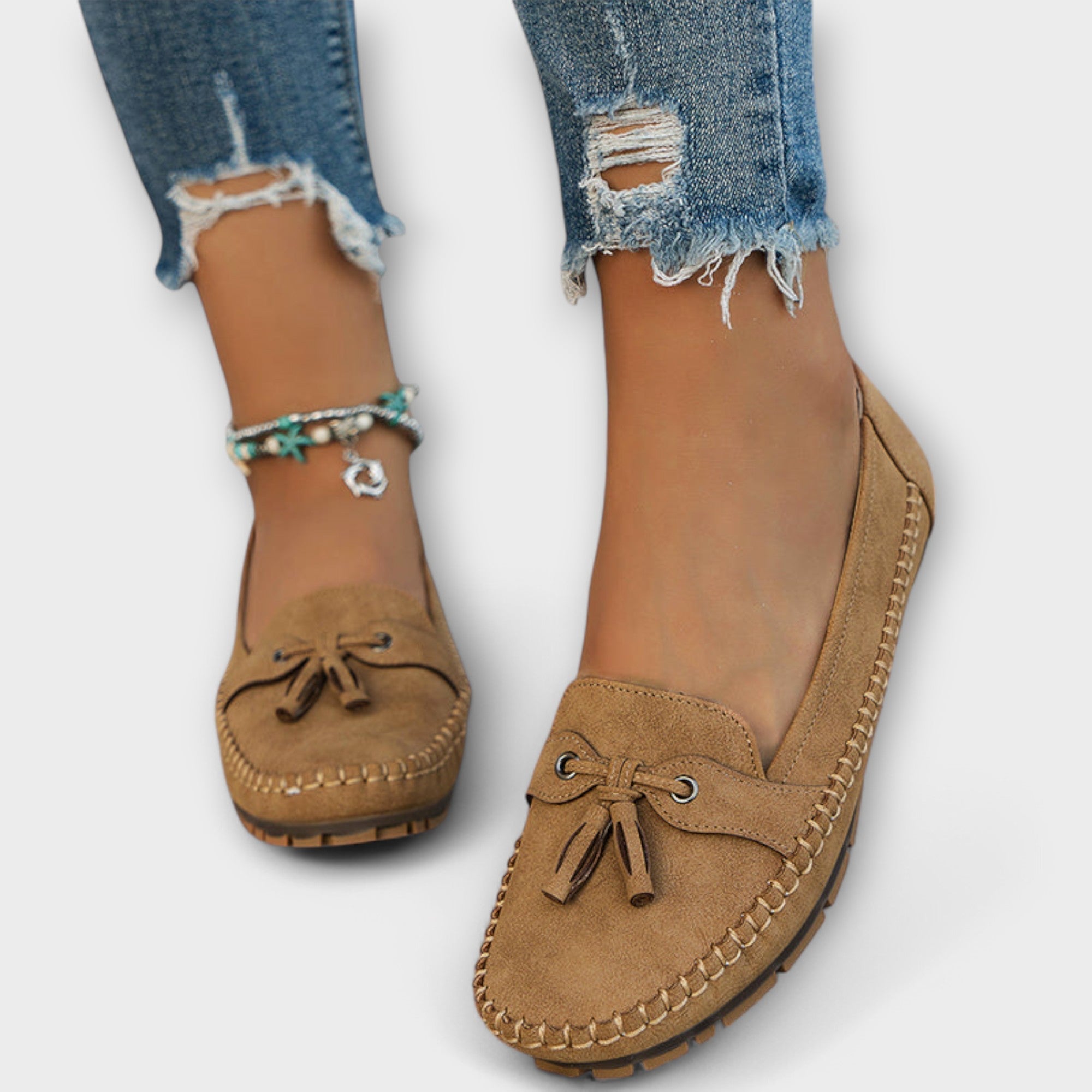 Women's suede moccasin loafers showing hand-stitched sole edging