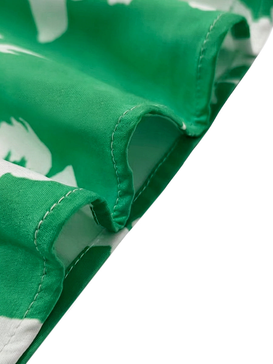 Close-up of side-split hem detail on green floral print maxi dress