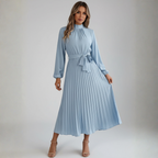 Women's long pleated dress with belt, side profile view