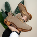 Khaki knit trainers with translucent amber sole, close-up hand-held view