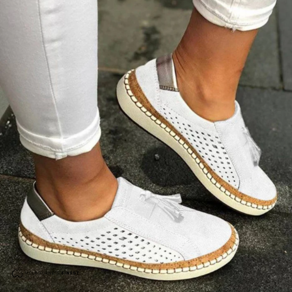 Women's perforated slip-on flat shoes in white – tassel detail side view