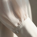 Women's wedding dress detail showing deep V-neckline and puff sleeves