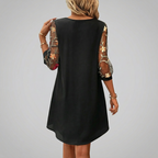 Floral embroidery detail on sheer sleeves of women's mini dress