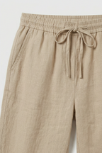 Women's roll-up linen trousers, close-up of drawstring waist detail