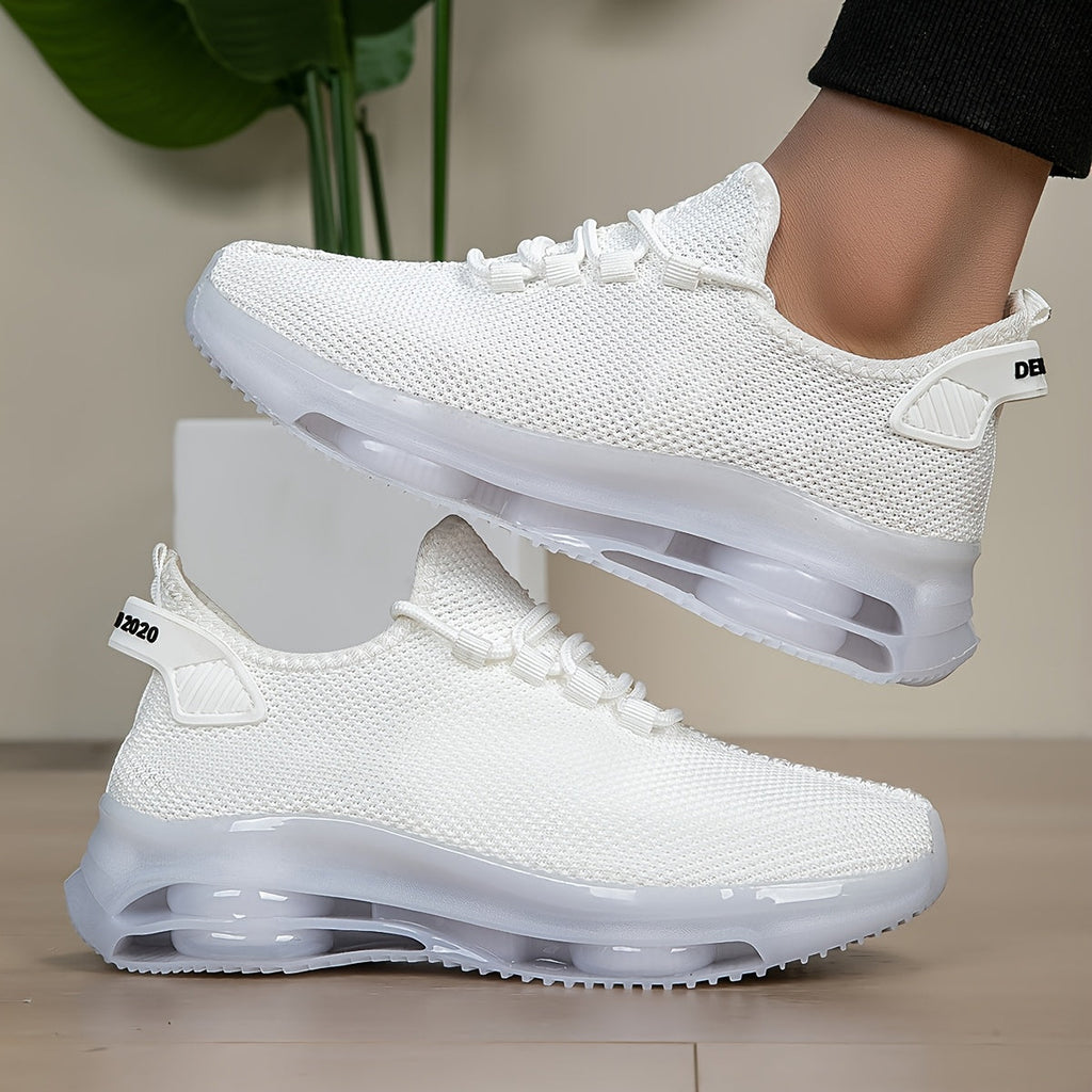White knit trainers, side view, one worn on foot and one placed on the floor