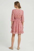 Women's silky mini dress with pleats, close-up of ruffle hem detail