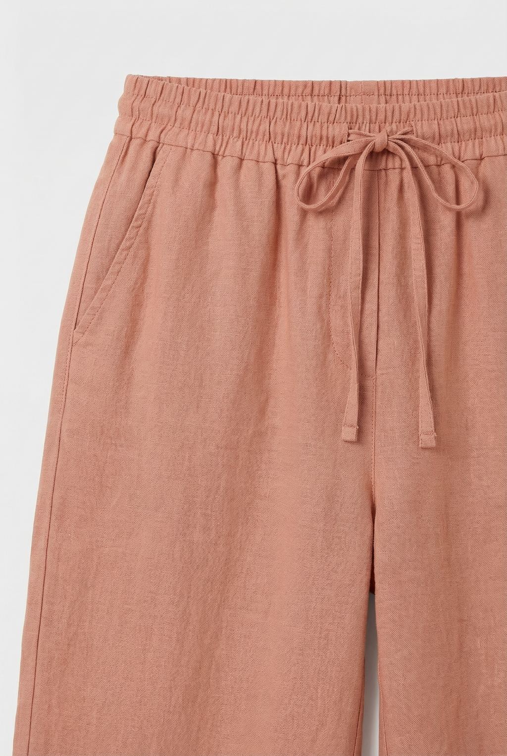 Women's high-waisted linen pants styled with a blouse, full length