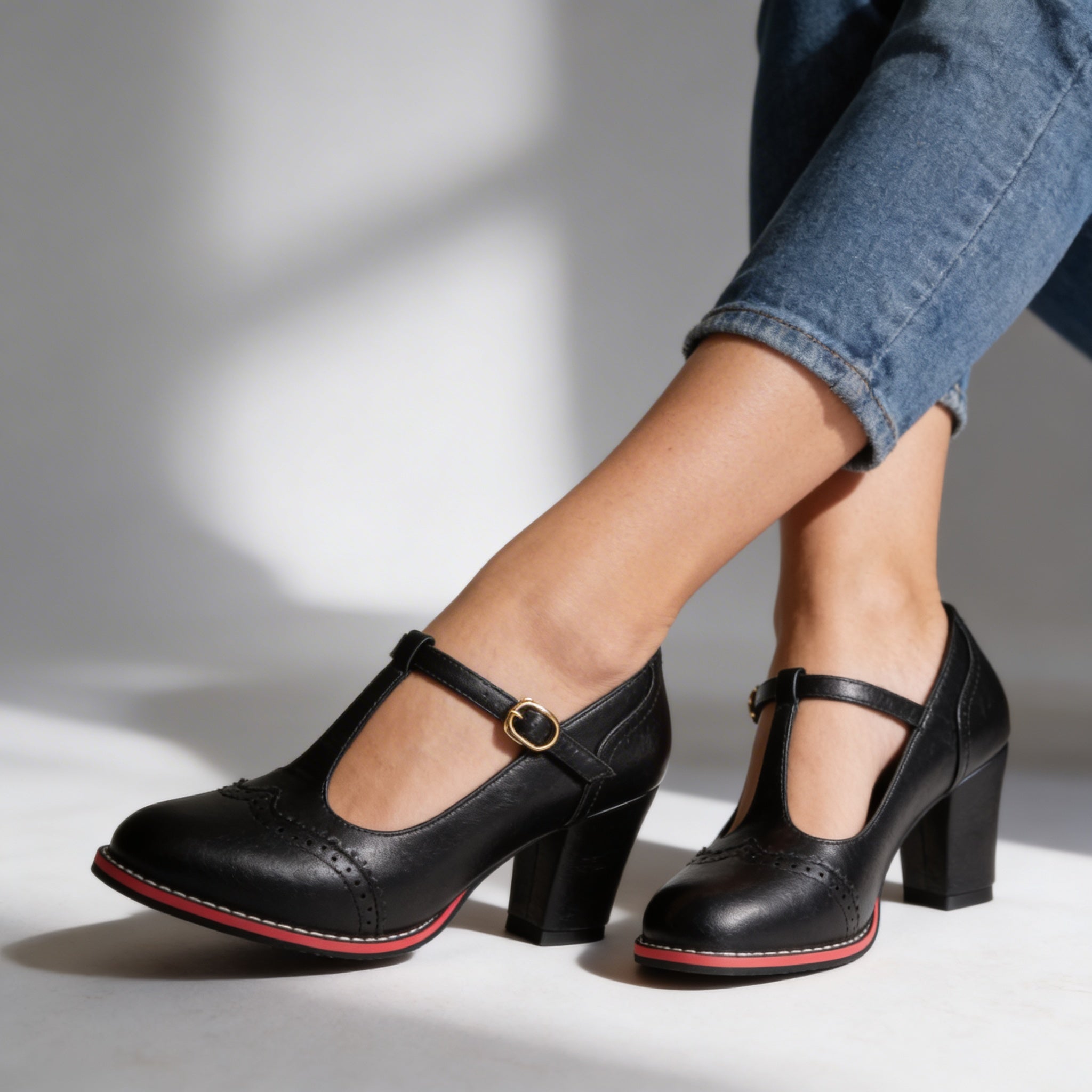 Black T-strap brogue Mary Jane block heels on model, side view studio shot