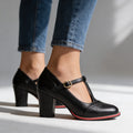 Black T-strap Mary Jane block heels close-up on model's feet outdoors
